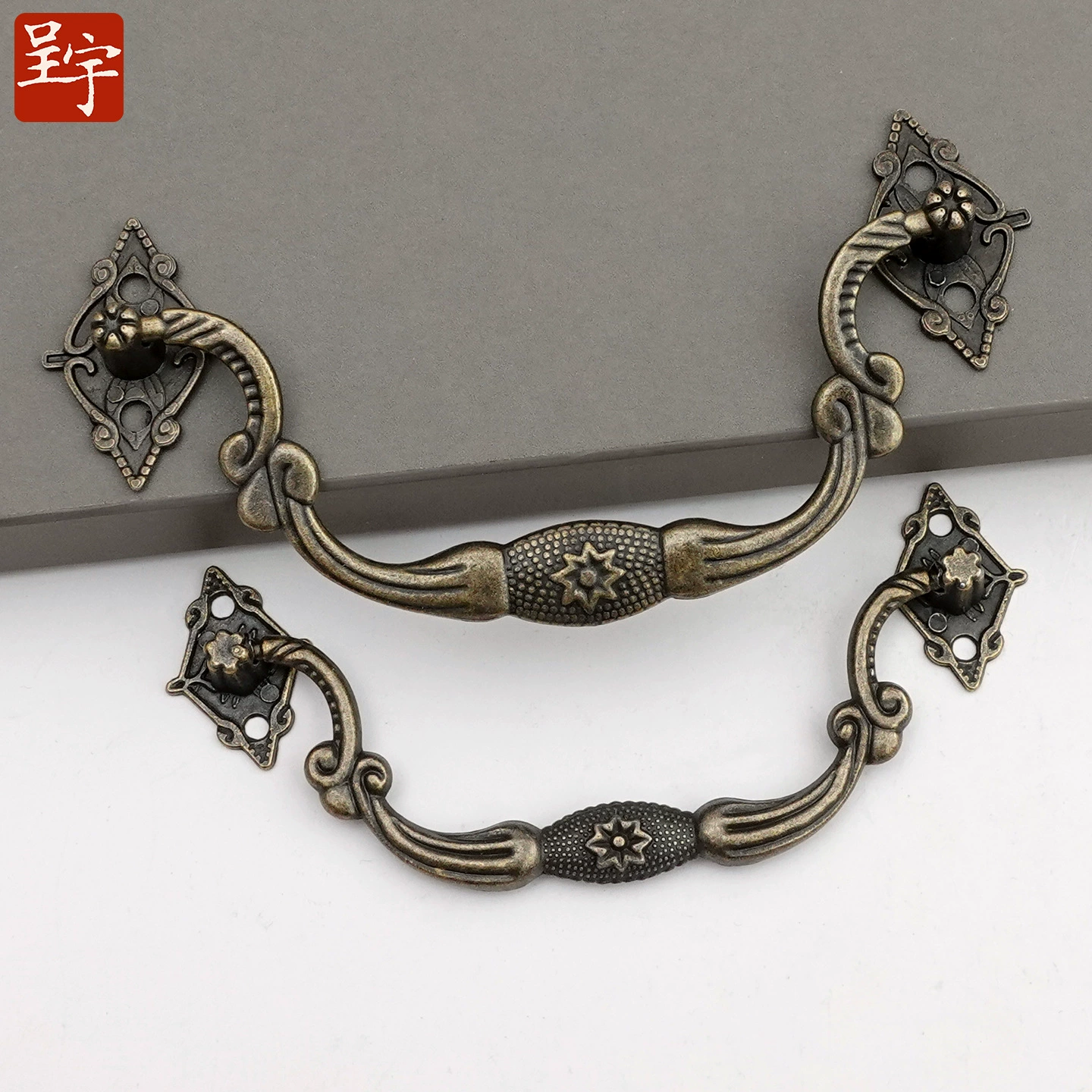 Antique‑style metal drawer handle, decorative bronze/golden finishes, multiple motifs