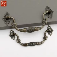Antique‑style metal drawer handle, decorative bronze/golden finishes, multiple motifs