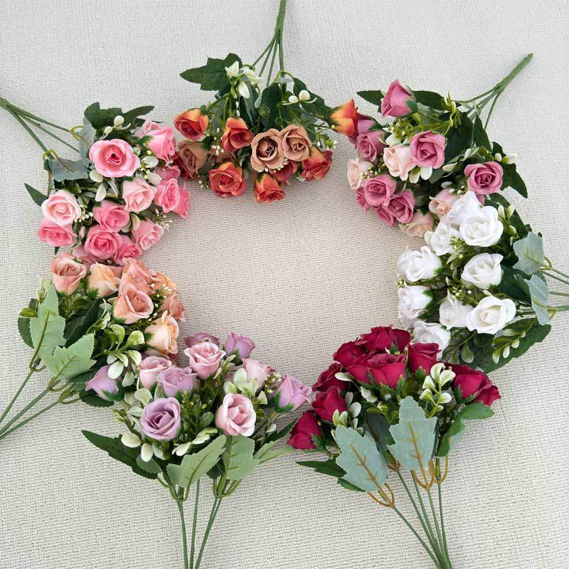 模造花ミニバラは花を手にして家にいる結婚式の室内客間の装飾に造花を飾っている|undefined