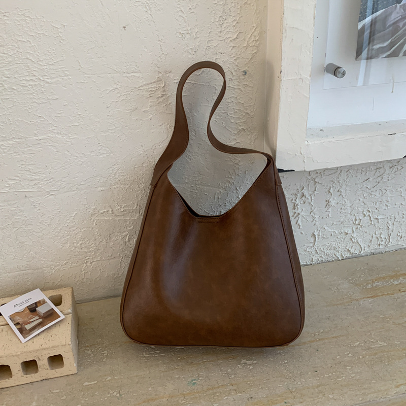 Nicho de diseño simple bolso de cubo portátil para mujeres 2026 primavera nueva moda perezosa retro bolso de brazo diario