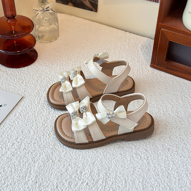Sandálias de niñas 2026 verano nuevo estilo coreano arco para niñas zapatos de playa de dedos desnudos estudiantes zapatos de princesa