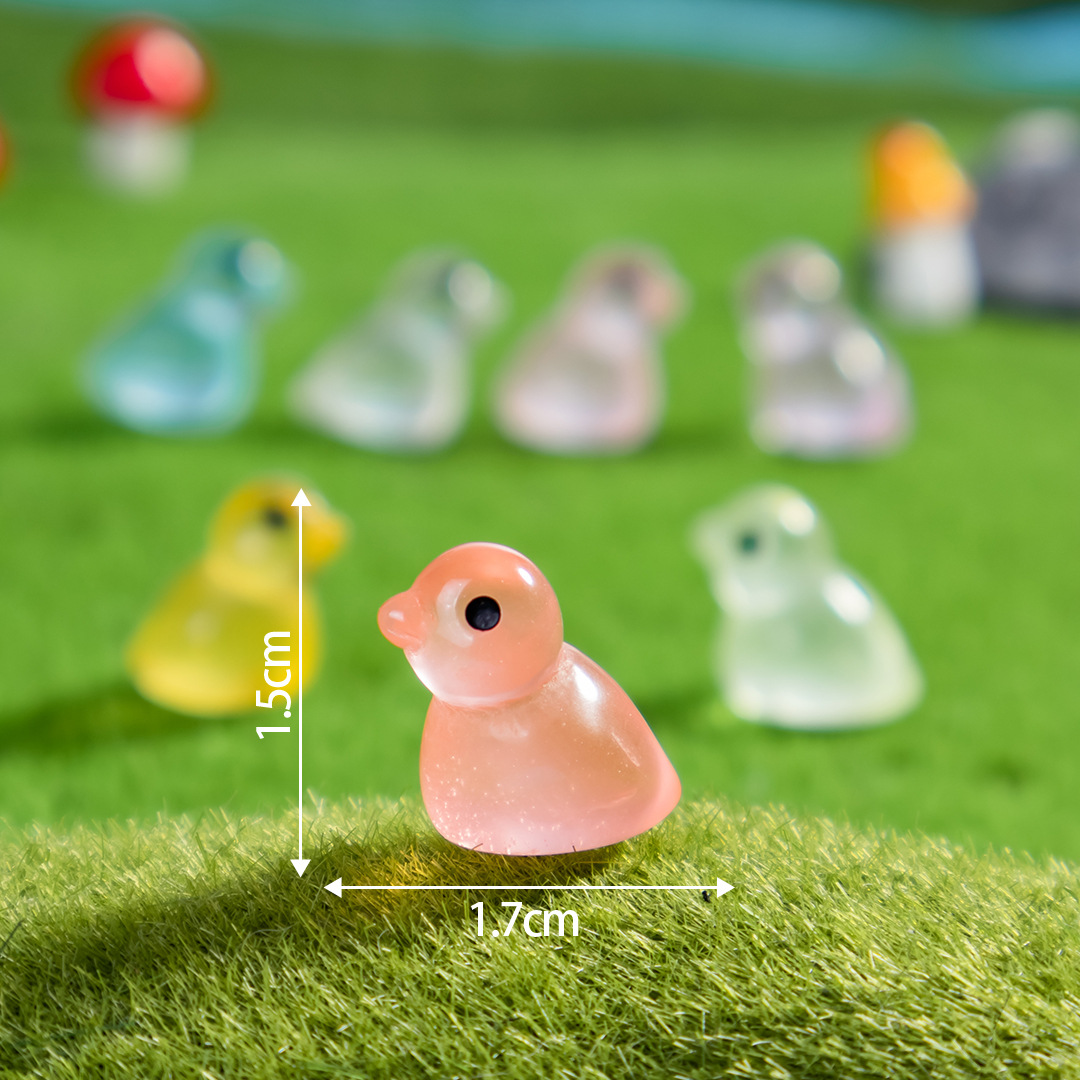 어둠 속에서 빛나는 작은 동물 펭귄이 앉아 혼합된 포즈를 취하고 있습니다.