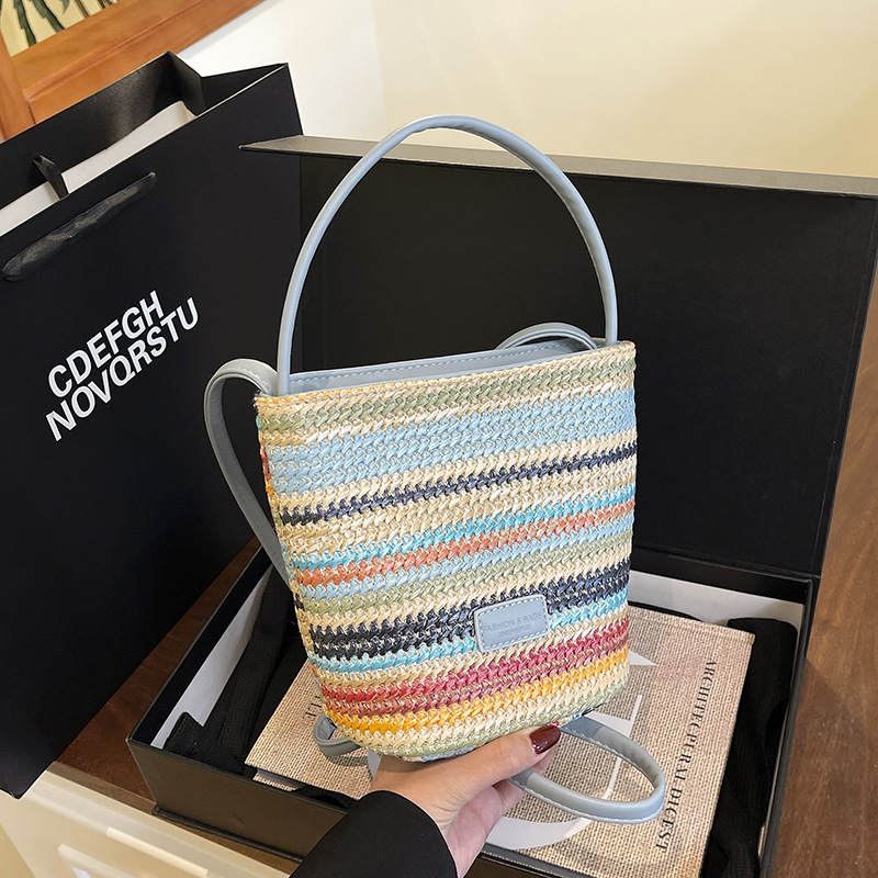 Bolso de cubo de vacaciones junto al mar 2025 nuevo bolso de mujer bolso de hombro tejido de paja de playa bolso de mensajero de color de contraste a rayas