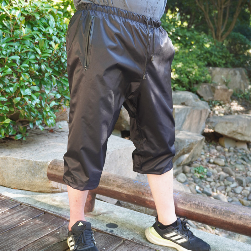 주머니와 끈이 달린 검은 자른 바지