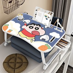 ベッドの上で小さい机のノートパソコンの机を畳んで、怠け者の学生は寮の寝室を勉強します。