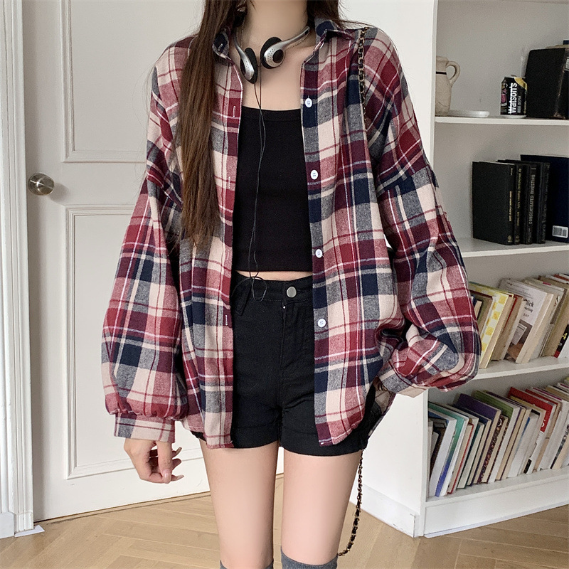 実際に日韓のレトロな格子のシャツの女性の外で長袖のシャツのコートの上着のゆったりしている設計感の長袖のコートをたたきます。