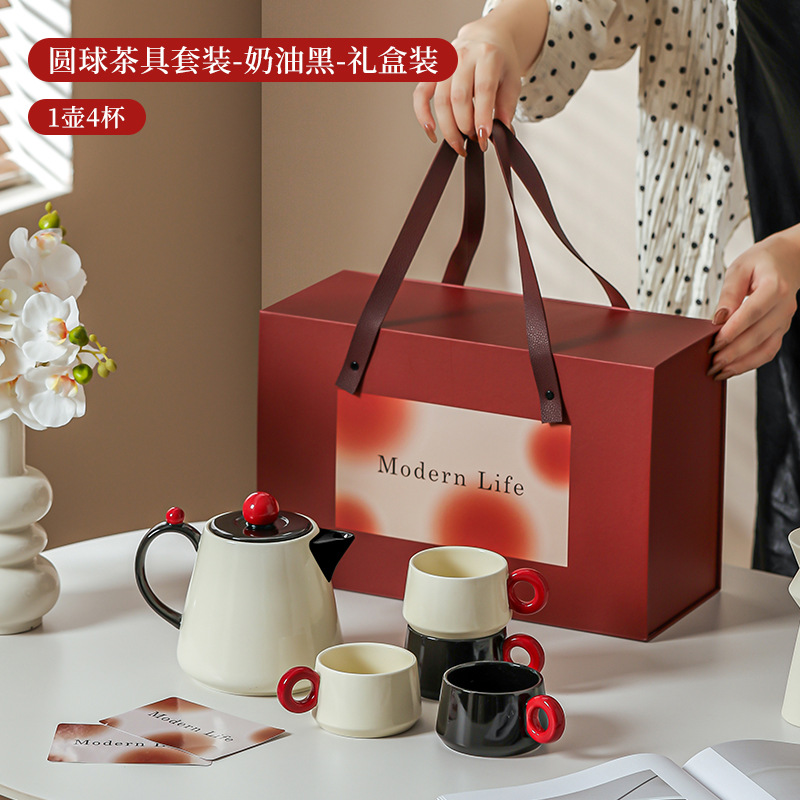La ama de casa moderna es la misma creativa encantadora de alto valor de la cara con un conjunto de utensilios de agua de cerámica doméstica para invitados con un conjunto completo de tetera de té