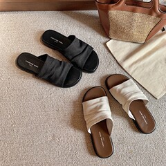 バンコクのドラッグ ~ リゾート風のビーチの亜麻のしわの平底のサンダルの女性は夏を着ています。