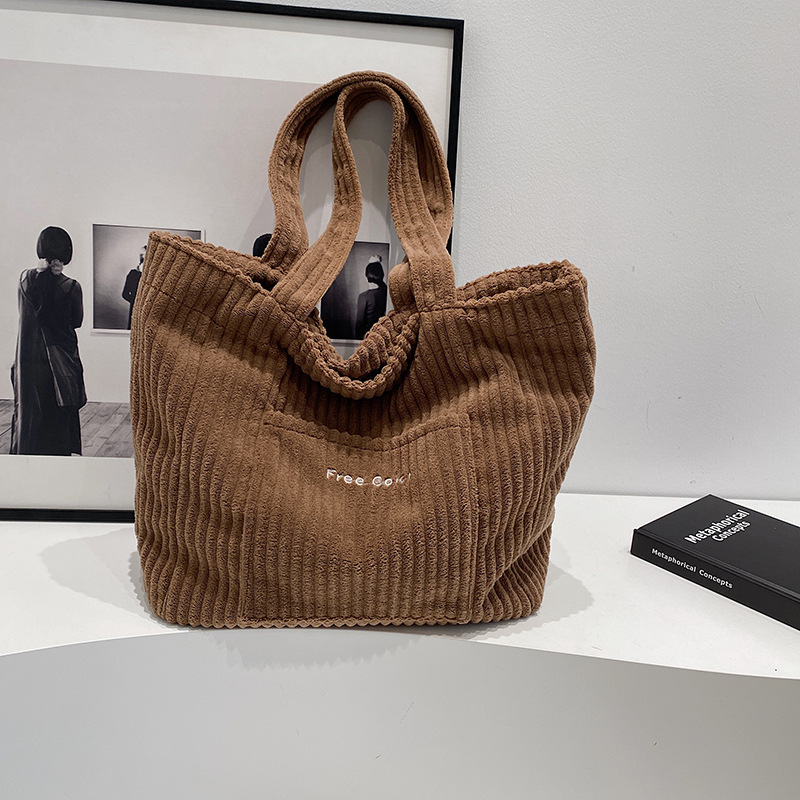 卸売りのリュックサックの女性はカジュアルなコーデュロイを合わせて大容量のトートバッグを持っています。|undefined