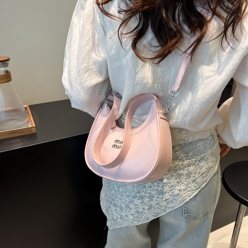 Bolso de axila de fuego súper transfronterizo para mujer 2025 nueva versión coreana de la bolsa de media luna de diseño de nicho bolsa de bola de masa cruzada de sentido avanzado