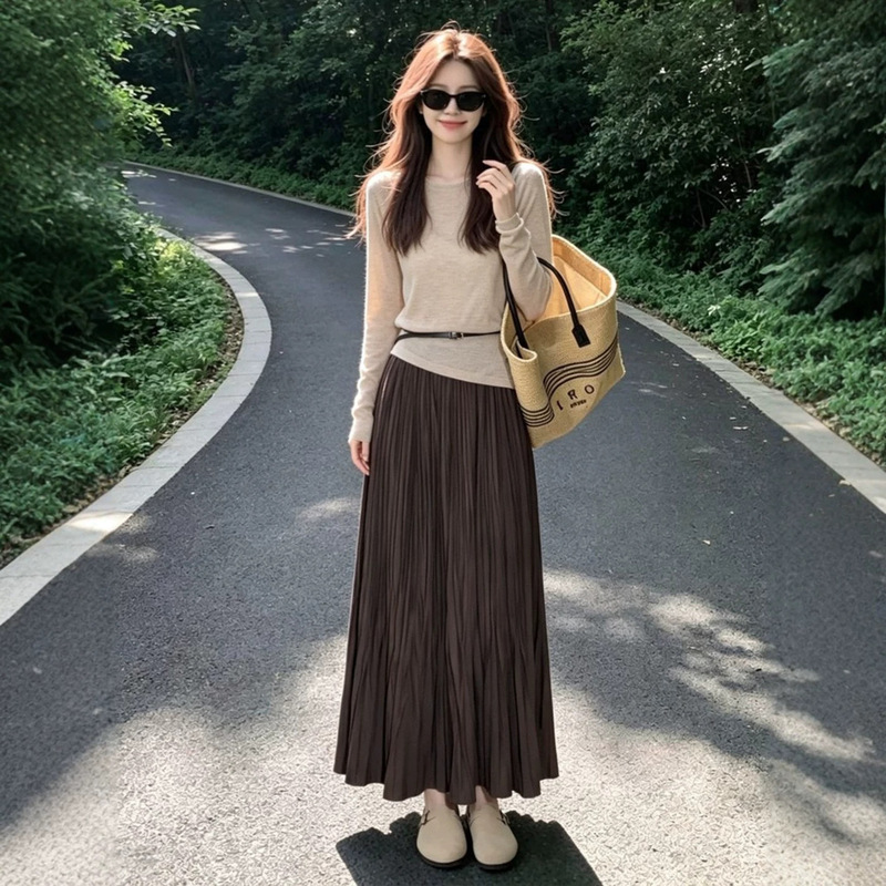 A sophisticated and stylish outfit: an oatmeal-colored knitted sweater paired with a brown pleated skirt, a two-piece set for women, perfect for early autumn