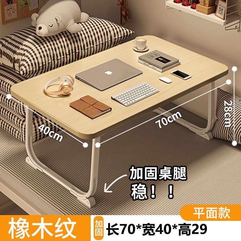 ベッドの上の小さい机のノートパソコンの机の上で折り畳みます。|undefined