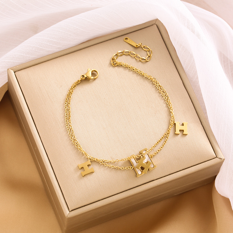 Pulsera de trébol de acero titanium vendedora caliente transfronteriza europea y americana con incrustaciones de concha pulsera colgante pulsera de diseño avanzado sin desvanecimiento al por mayor