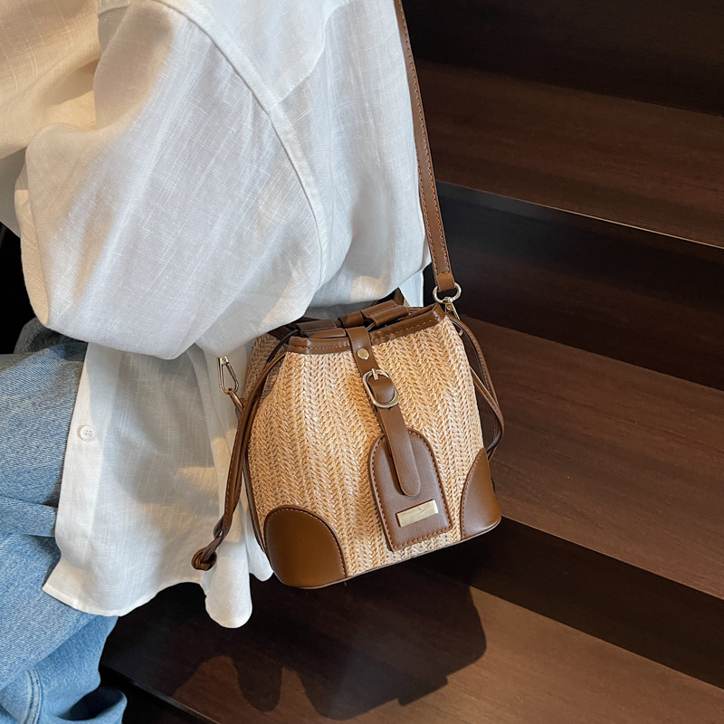 Bolso tejido femenino 2025 verano nuevo estilo juego junto al mar bolso de cubo de viaje tendencia bolsa de paja de mensajero de todo fósforo de nicho