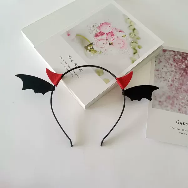 A headband with red horns and black wings