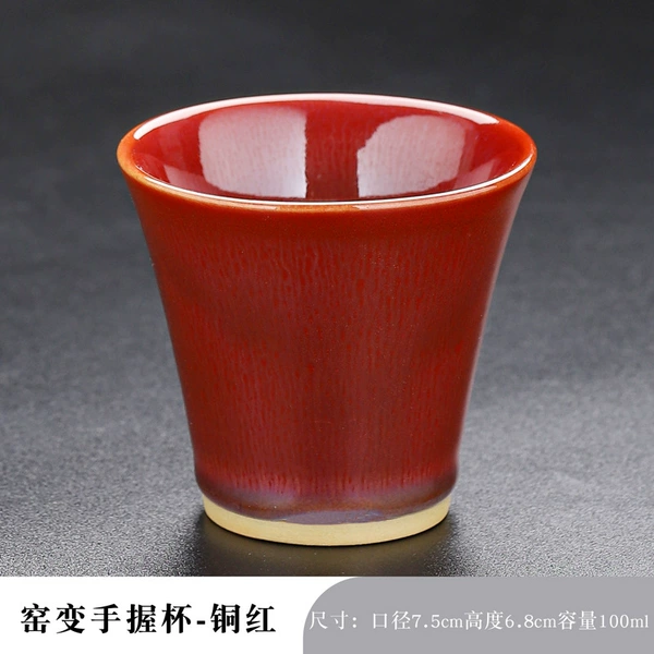 The kiln changes and the hand holds the cup of tung red
