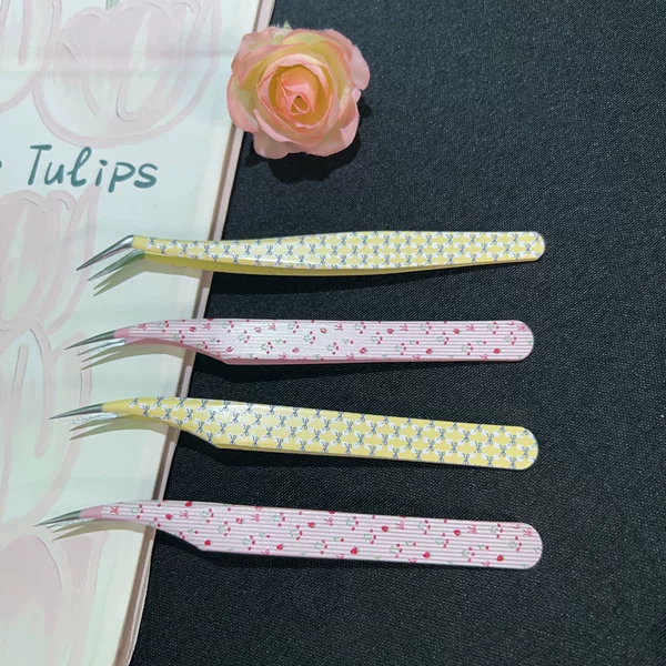 High-precision stainless steel gold feather tweezers for eyelash extension, used for creating detailed designs in journals and for precise application of cartoon stickers