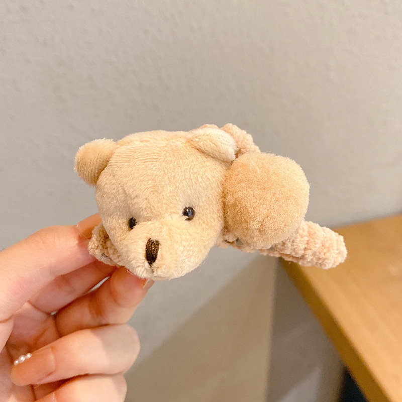 熊の高いポニーテールは女性の秋冬の後頭部を挟んでカードのぬいぐるみの爪を挟みます。|undefined