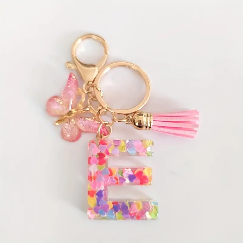 2024 transfronteriza en stock resina rosa con lentejuelas 26 letras inglesas llavero colgante mariposa borla Accesorios