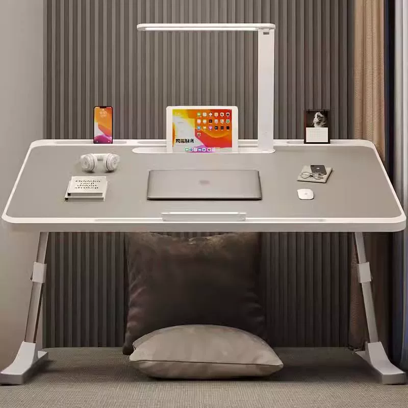 Небольшой стол с настольной лампой можно поднять и сложить стол на кровати