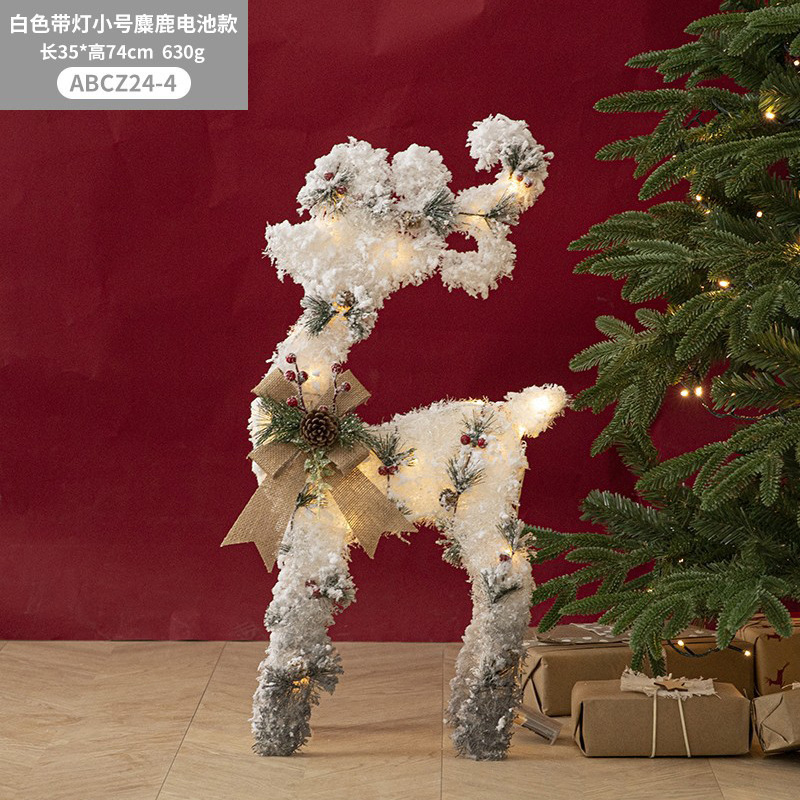 Decoraciones navideñas de muñecos de nieve, adornos de escaparate con una escena de renos de peluche blancos brillantes para la Nochebuena.