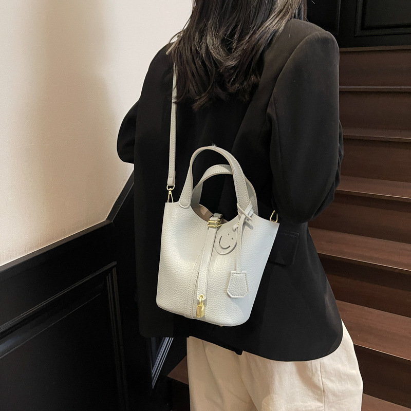 Bolso de cubo portátil con patrón de lichi de alta gama para mujer 2025 nuevo bolso de hombro de todo fósforo de moda bolso de mensajero casual de estilo occidental