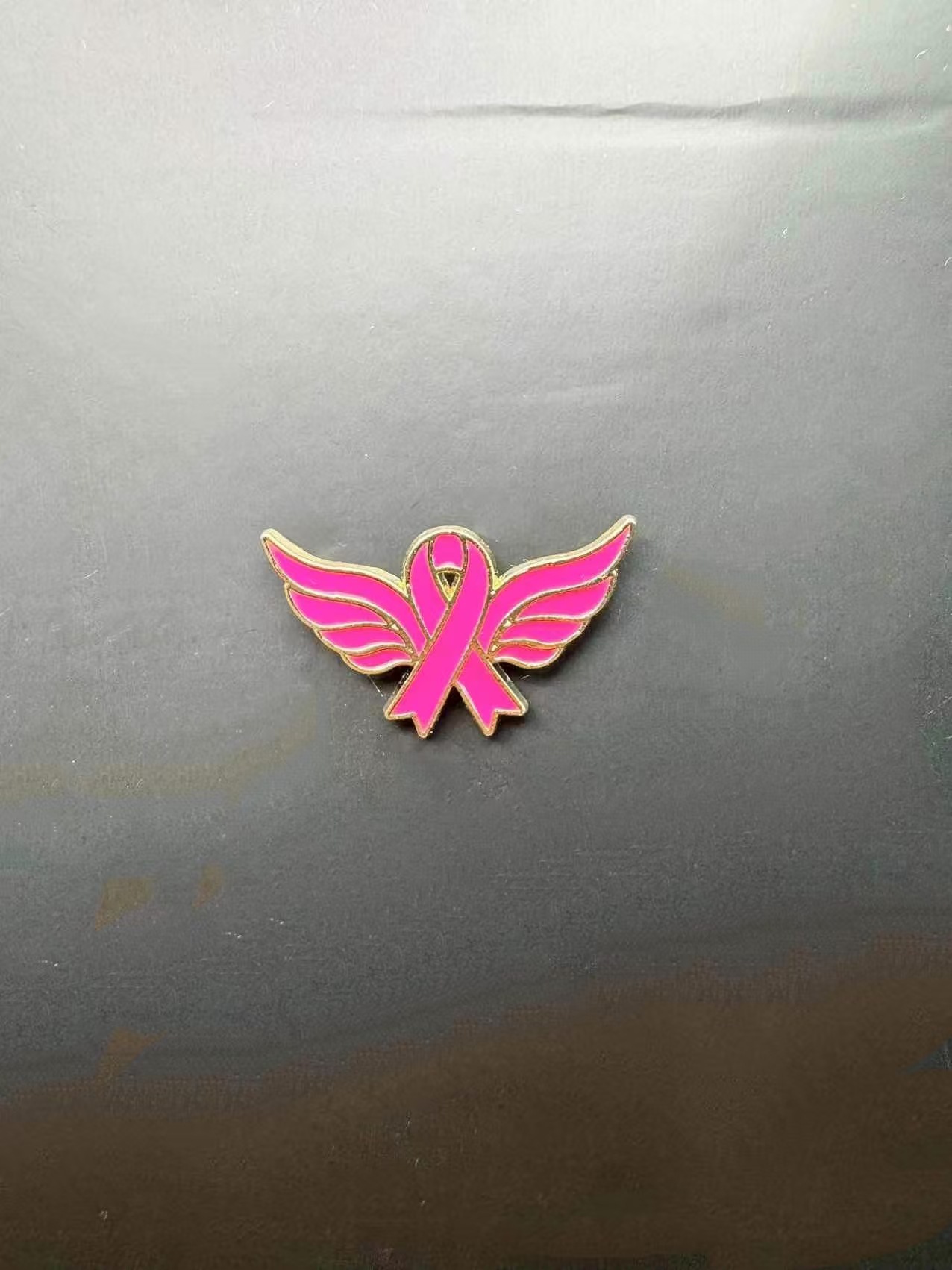 Broche promotionnelle avec logo du Ruban Rose International, symbole de sensibilisation au cancer du sein_voghion.com
