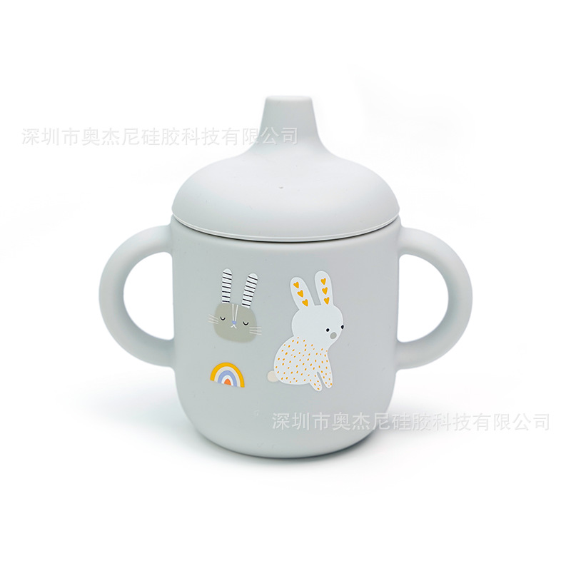 Taza de aprendizaje para bebés de silicona de grado alimenticio - 180 ml - Con boquilla y asas - Estampado disponible - En stock - Venta al por mayor