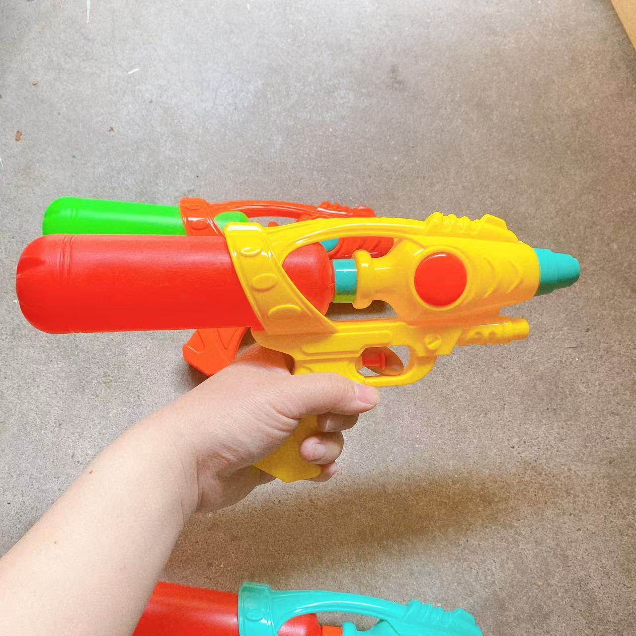 Pistola de agua de juguete para niños jugando en la playa