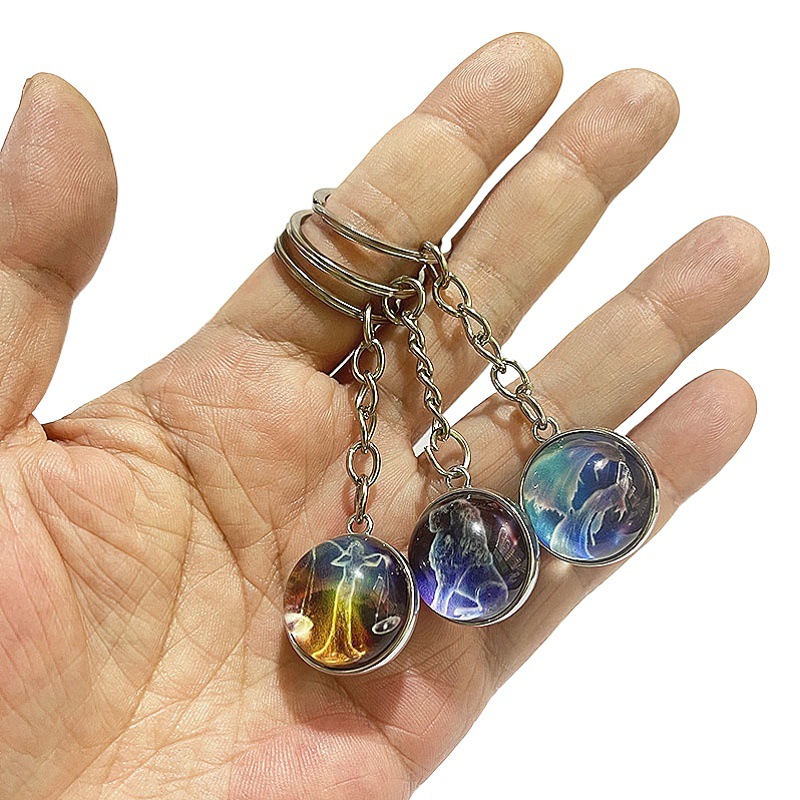 Amazon Venta caliente fantasía doce constelación luminosa bola de cristal de doble cara llavero colgante accesorios al por mayor