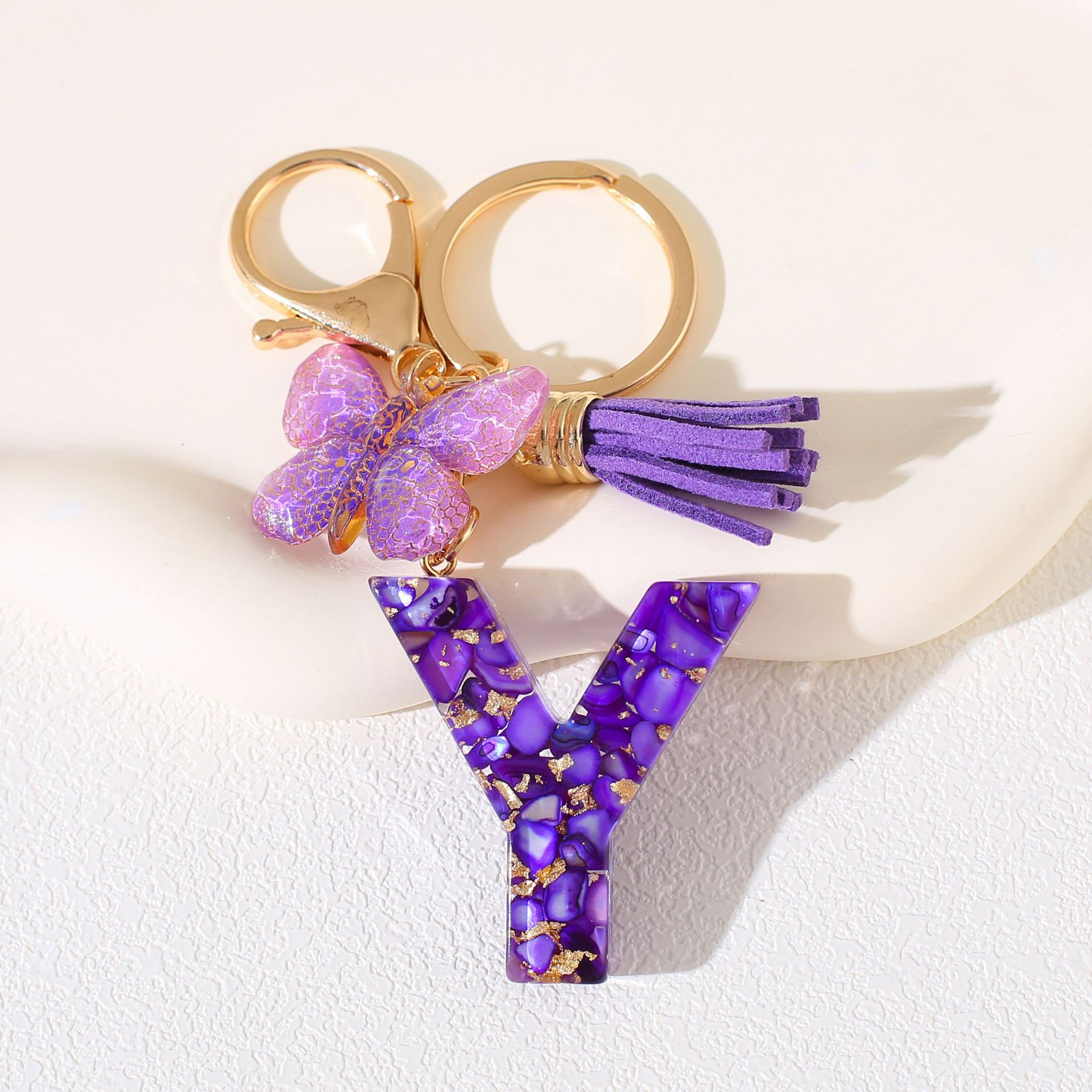 Fábrica directa de Yiwu accesorios de resina de goteo de embalaje llavero anillo de metal letras mariposa brilla colgante damas