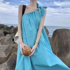 海辺のリゾートワンピースの女性は肉を遮って痩せています。