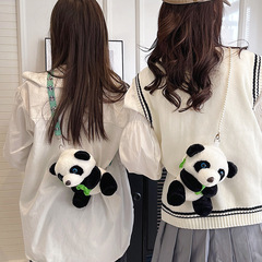 新しいかわいいパンダのぬいぐるみはぬいぐるみを包んで、斜めに女性の肩を包んでいます。