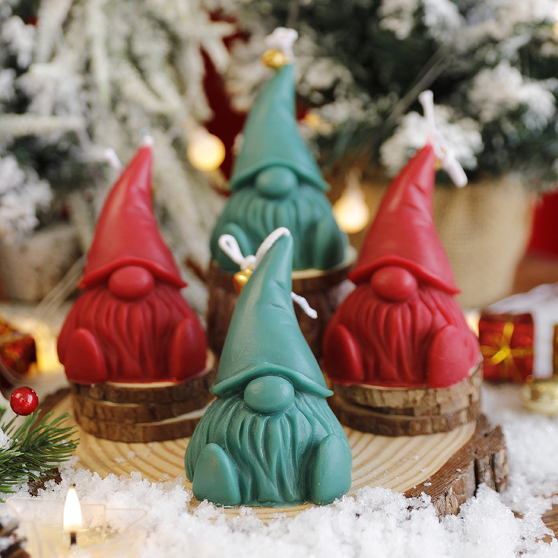 Santa Claus se sienta en una vela perfumada de invierno con un conjunto de regalos para adornos de flores.