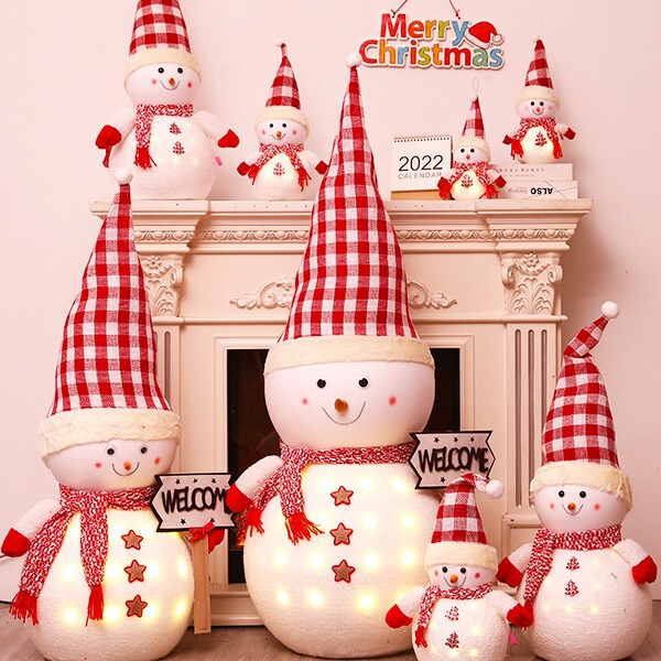 クリスマス発光雪だるま人形のデスクトップに子供の祝日のプレゼントを飾っています。|undefined