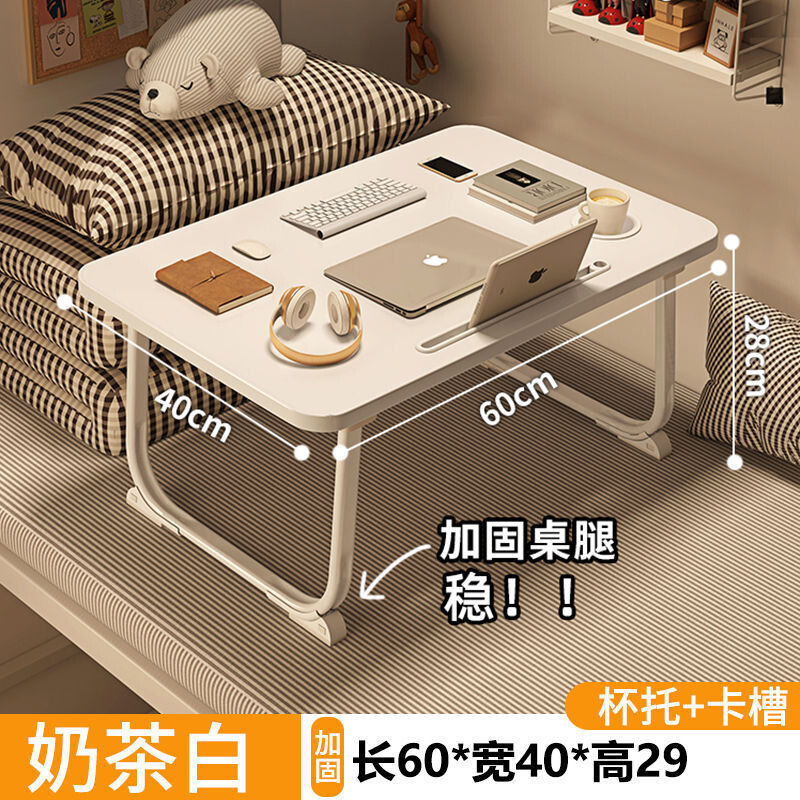 ベッドの上の小さい机のノートパソコンの机の上で折り畳みます。|undefined