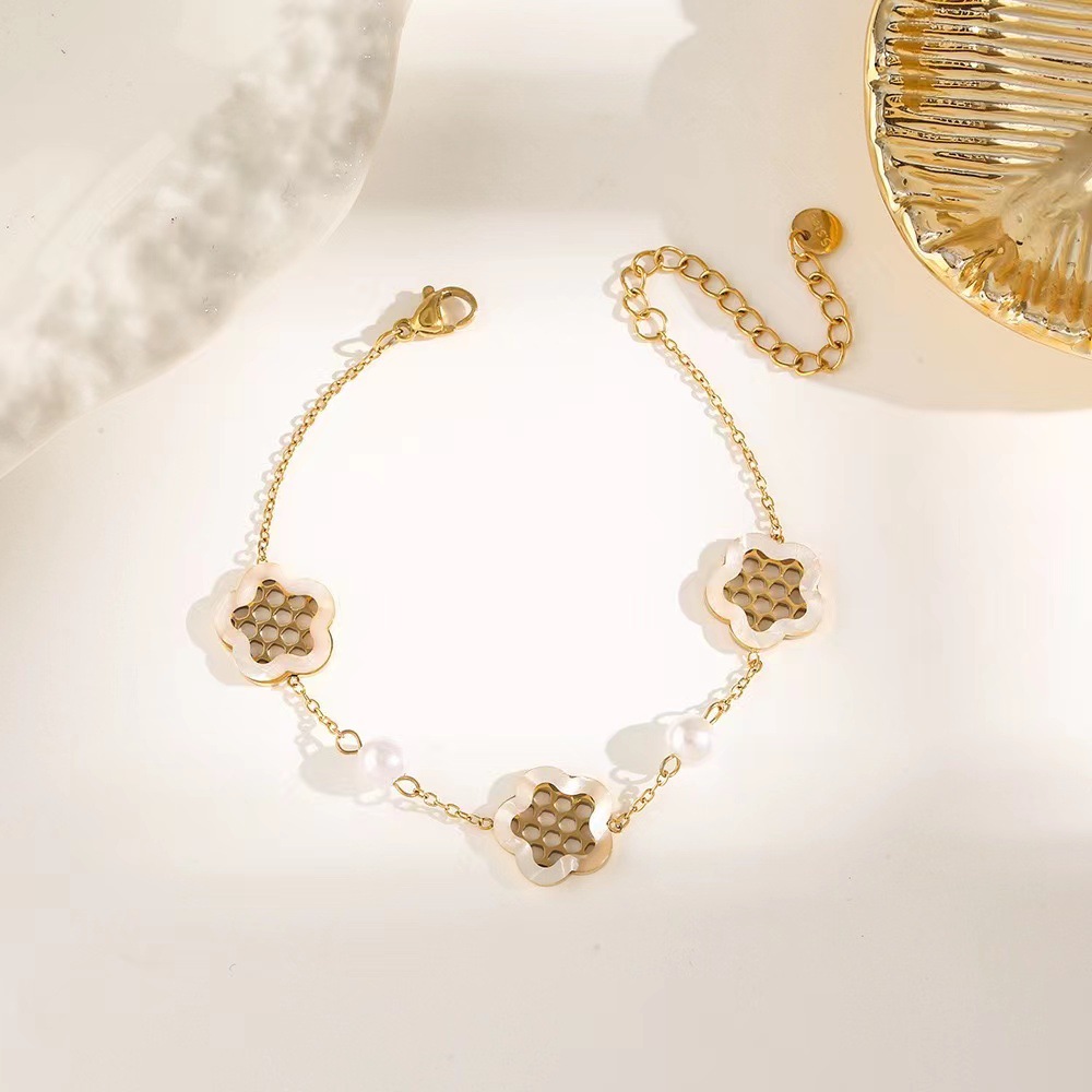 Pulsera de trébol de acero titanium vendedora caliente transfronteriza europea y americana con incrustaciones de concha pulsera colgante pulsera de diseño avanzado sin desvanecimiento al por mayor
