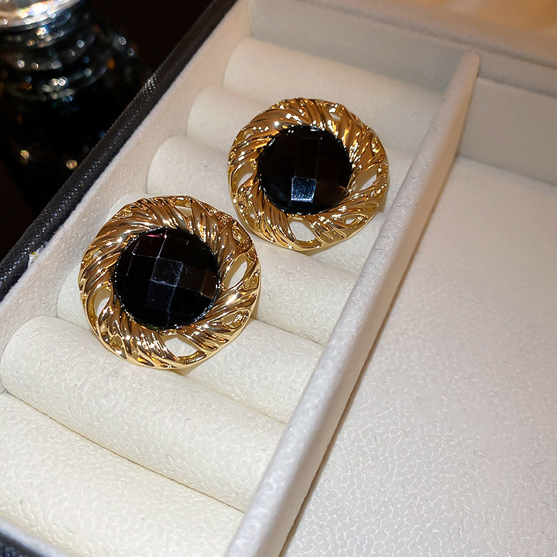 Pendientes de botón redondos con diseño de espiral, acentuados con diamantes y aguja de plata.