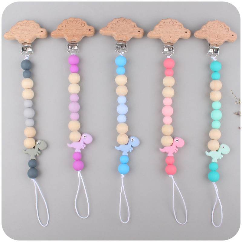 Suministros para bebés pulsera de silicona molar de juguete para niños Cadena de cochecito de dinosaurio de tres piezas creativa pequeña campana colgante