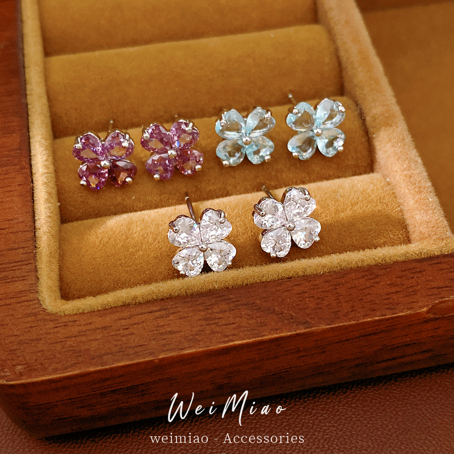 Agujas de plata zircon flores de hierba afortunada simple estilo de viaje versátil pendientes ligeros de lujo alta sensación de auriculares al por mayor