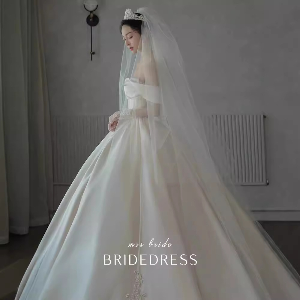 Vestido de novia principal al estilo de Gao Luo, nuevo modelo 2026, estilo retro francés de satén con hombros descubiertos para novias pequeñas, disponible para venta al por mayor.