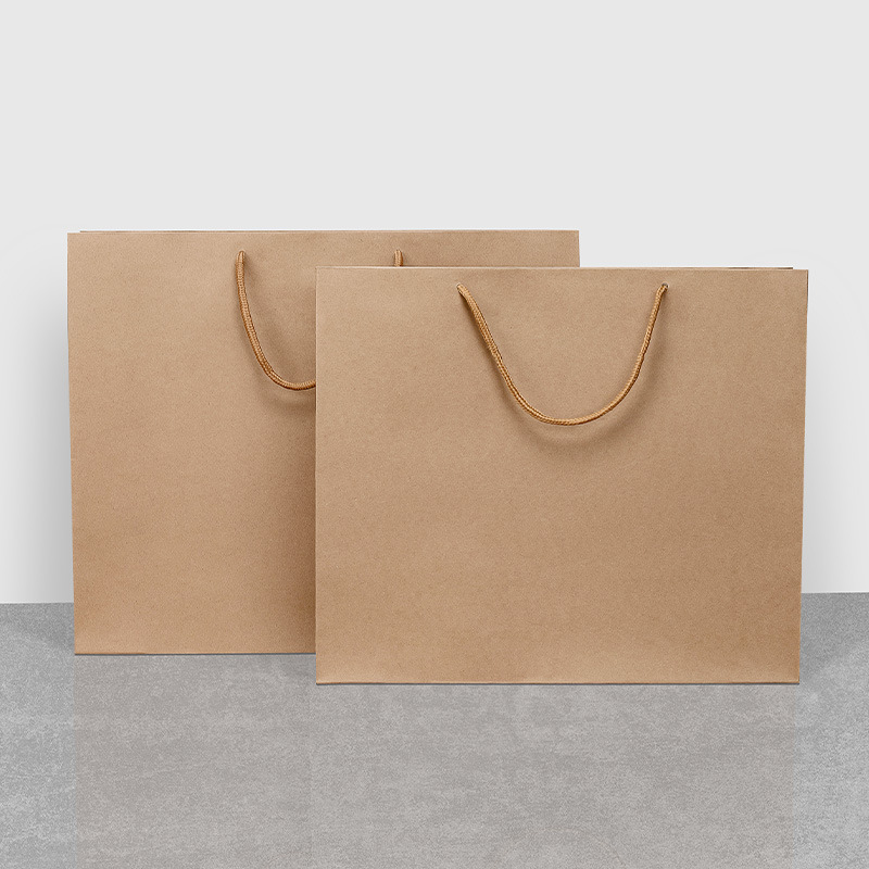Bolsa de regalo de papel Kraft bolsa de embalaje de cartón negro en stock bolso de regalo de ropa ventas directas de fábrica