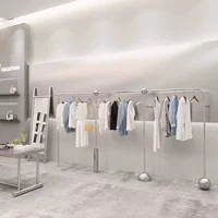Стойка для витрины магазина одежды из нержавеющей стали из шелка и серебра на стене витрина