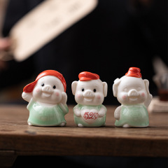 ミニ陶磁器のかわいい子豚が家のアニメデスクの装飾品を飾っています。