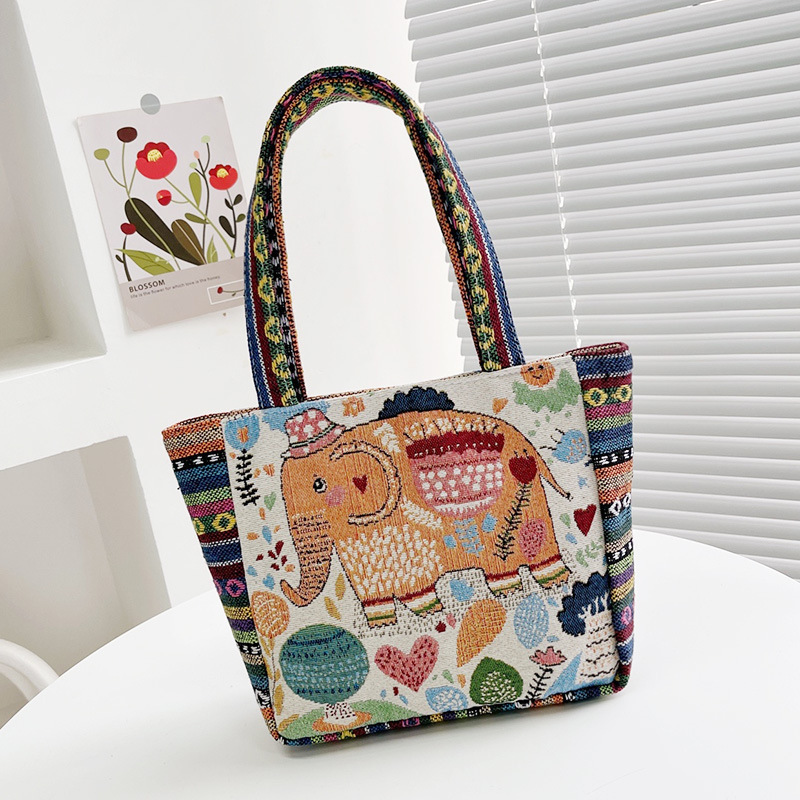 国境を越えた刺繍キャンバスのハンドバッグは女性民族風のハンドバッグを持ってカジュアルなマミーバッグのサラリーマンが弁当袋を持っている|undefined
