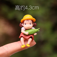 かわいい日本のアニメの周辺はトウモロコシの女の子の手を抱いて模型の黒い石炭のボールの精霊のコケの小さい景観の置物を作ります。