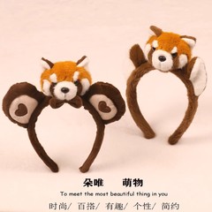 秋冬のかわいいアライグマのぬいぐるみのカチューシャの女性の顔を洗って化粧します。