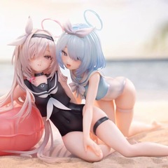 夏の砂浜の水着の青いファイルの水着の水着の輪のアロナ & プラナの手は型を作ってプレゼントの彫像を遊びます。