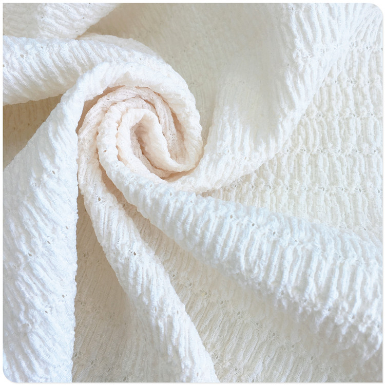 厂家供应交织经编氨纶花式花纹洞洞提花绉布抽条镂空女春夏装新