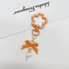 Orange keychain with bow, flowered